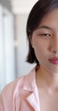 Vertical video half face portrait of asian woman blinking and smiling, copy space, slow motion. Business, work and communication concept.