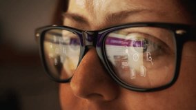 Cg footage with reflection in glasses on a female face searching for information on the Internet and rotating symbols of business documentation