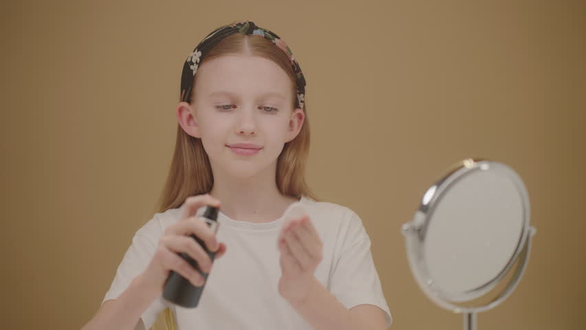Cute teenage girl using facial spray and cotton pad to cleanse and hydrate her face. Concept beauty and skincare products for teens. Caucasian girl in white t-shirt make a beauty routine 