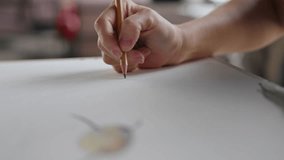 Female artist drawing on piece of paper using pencil. Painter creates sketch on blank canvas in well-lit studio, close-up shot - Powered by Shutterstock - Get 15% off with code: PIKWIZARD15