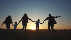 family runs across the field. happy childhood concept for little child. big happy family running across field on the grass lifestyle holding hands, sunset on the background, silhouettes - Powered by Shutterstock - Get 15% off with code: PIKWIZARD15