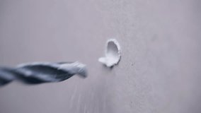 Metal drilling bit making hole in drywall for further screw fixation, process of plasterboard drilling with working tool, steel instrument for walls renovation. High quality 4k footage - Powered by Shutterstock - Get 15% off with code: PIKWIZARD15