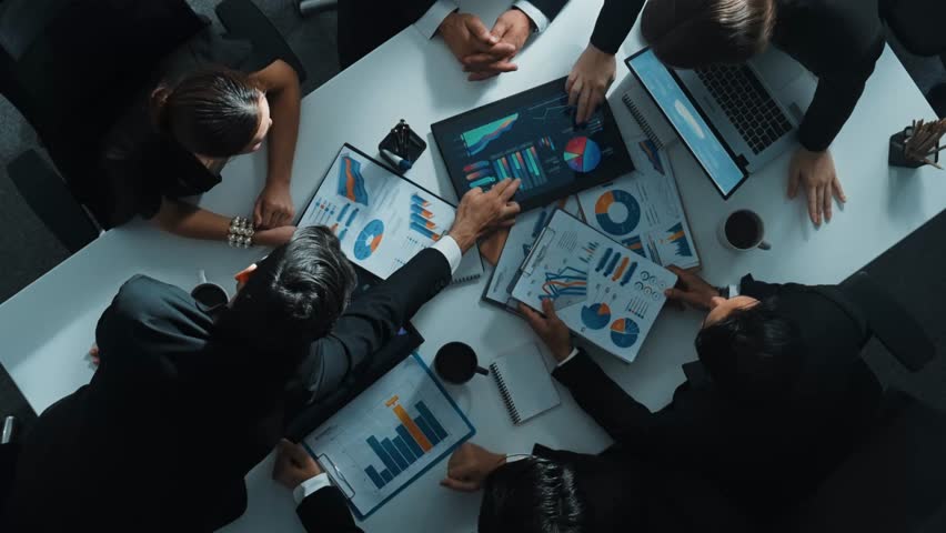 Top down aerial view of professional businessman handed out financial statistic to analyst data investment graph. Group of diverse investors brainstorming and planning marketing strategy. Directorate. Royalty-Free Stock Footage #3461258599