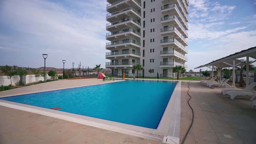 Modern apartment building with pool, landscaped yard for real estate promo. Potential tenants view amenities, investment attraction.