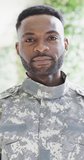 Vertical video portrait of happy african american male soldier smiling outdoors, slow motion. Happiness, military service and domestic life concept.