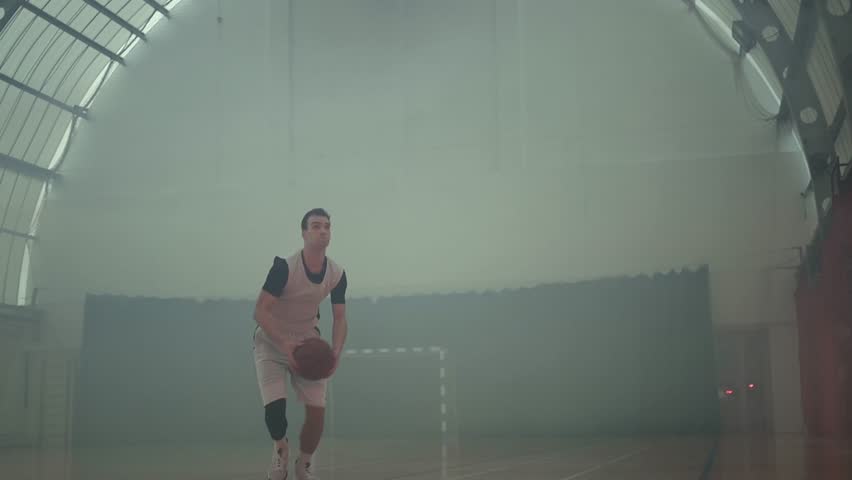 Professional basketball player training in an empty basketball stadium.