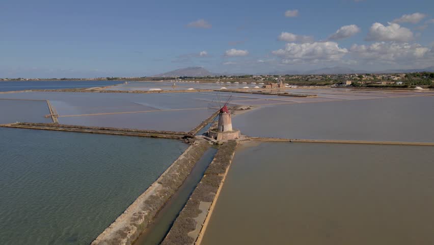 Salt Pans near Marsala at Sicily, Italy in Europe. colorful windmills at the saltpans of Sicily in summer at sunset