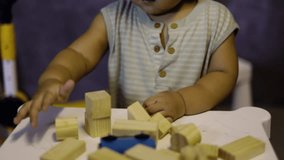Children play with wooden toys in the children room. Hands of kid playing the wooden block game is a way to learn and develop a way of thinking about concepts. Potential and the brain.