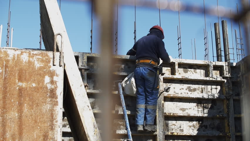 builder installs formwork on a construction site