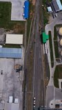 Field crossed by numerous roads. Territory occupied by different kinds of building materials for future plant construction. Aerial view. Vertical video