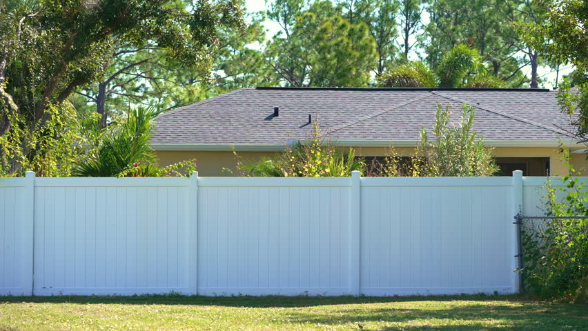 White vinyl fence surrounding private property grounds for backyard protection and privacy in southern Florida