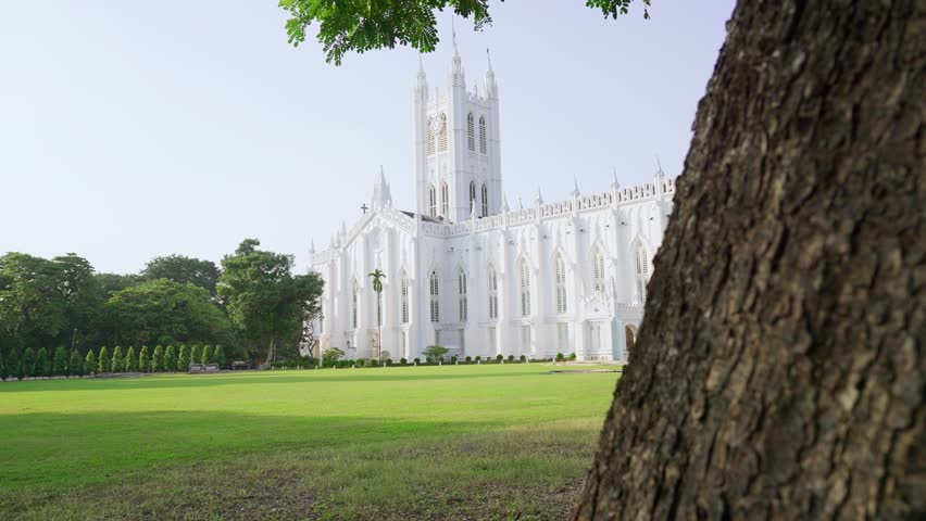 A movement daylight wide shot of the white heritage building of the Saint Paul Cathedral Church in Kolkata, West Bengal, India noted for its Gothic architecture and dedicated to Paul the Apostle.