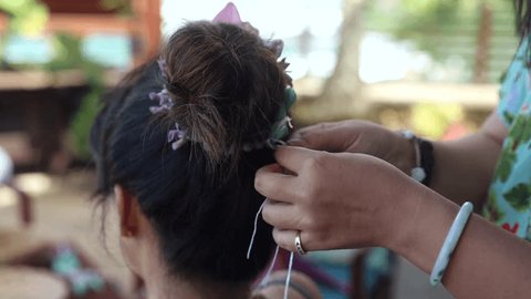 Close-up of a woman making lei in Hawaii, plumeria flowers garland crown handmade. 스톡 비디오