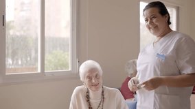 Caregiver smiling at camera next to old people in geriatric