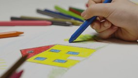 Close-up of hands of unidentified little child  drawing house .child coloring, colored pencils, preschool drawing - Powered by Shutterstock - Get 15% off with code: PIKWIZARD15
