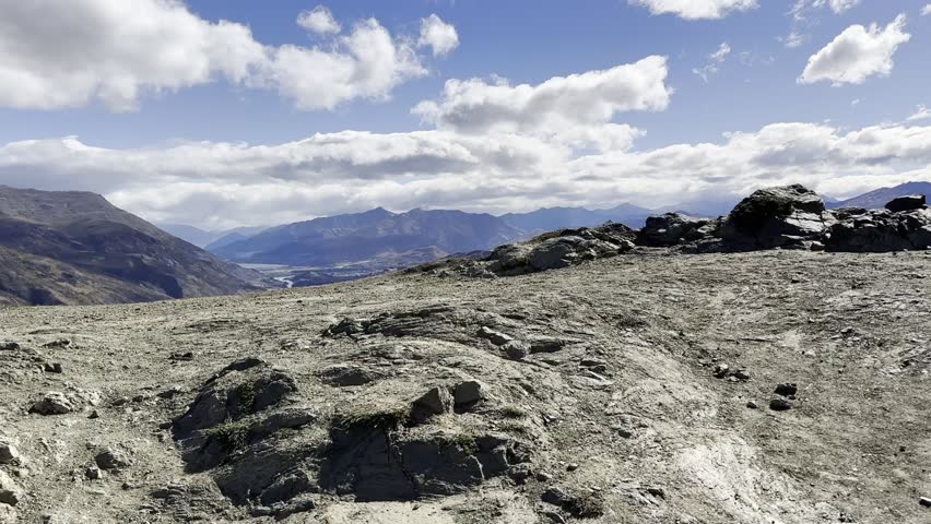 Walking up to the Crown Range Summit Lookout, View of The Remarkables, Queenstown Area, New Zealand. Valleys, Fields, Meadows, Farms, Paddocks, Vineyards, Shotover River. Sheer Dropoff, Cliff.