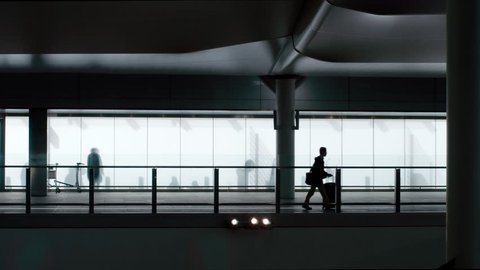 Heathrow Airport, UK 20 July 2016: Silhouette of passengers walking to the terminal.