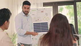 A businessman presents a solar panel during a team meeting focused on sustainability, renewable energy solutions, and ESG goals. - Powered by Shutterstock - Get 15% off with code: PIKWIZARD15