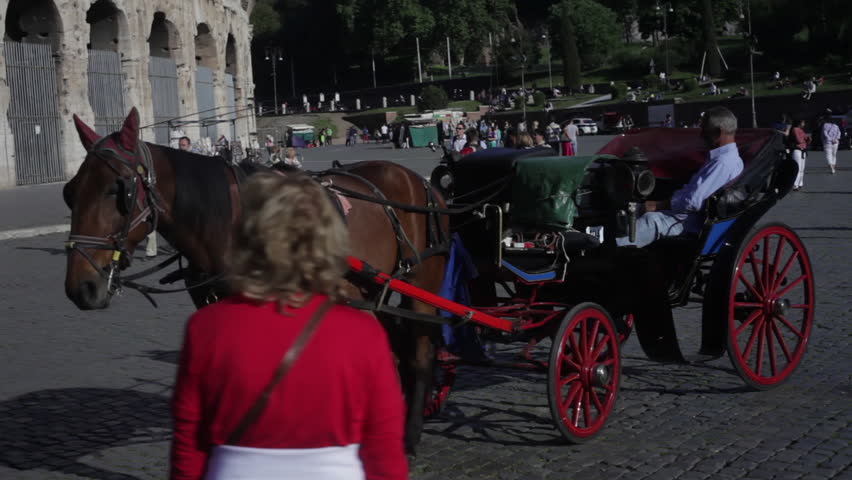 ROME - CIRCA MAY 2012: A horse-drawn buggy is parked in front of the Colosseum 