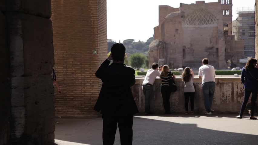 ROME - CIRCA MAY 2012: Tourists walking around taking pictures at the Colosseum 