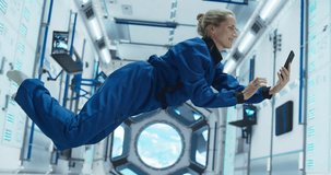 Astronaut Floating in Zero Gravity on Board a Spacecraft. Female Having a Video Call with a Family or Friends From Planet Earth. Engineer Using Smartphone in Space Inside an Orbiting Spaceship