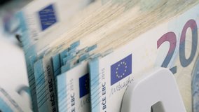Bill counter close-up of 20 euro banknotes macro top view slow motion. Bank automatic equipment for counting cash money. European union currency. Inflation, economy, investment, income. Euro banknotes - Powered by Shutterstock - Get 15% off with code: PIKWIZARD15