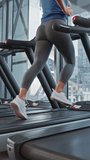 Beautiful Athletic Sports Woman Running on a Treadmill. Energetic Fit Female Athlete Training in the Gym. Athletes Workout in Fitness Club. Vertical Screen Orientation Video 9:16