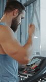 Muscular Male Athlete Inserts Wireless Headphones, Turns on Podcast or Music Playlist with Smartphone and Starts Running on a Treadmill. Leg and Cardio Gym Day. ertical Screen Orientation Video 9:17