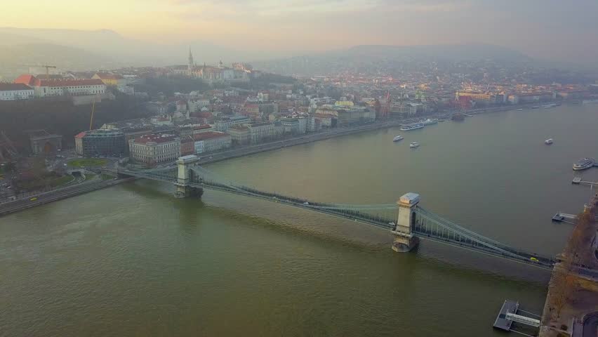Budapest, Hungary - Aerial drone footage of the famous Szechenyi Chain Bridge with Buda Castle Royal Palace at sunset