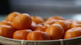 People hand putting fresh oranges fruits in basket closeup blur background