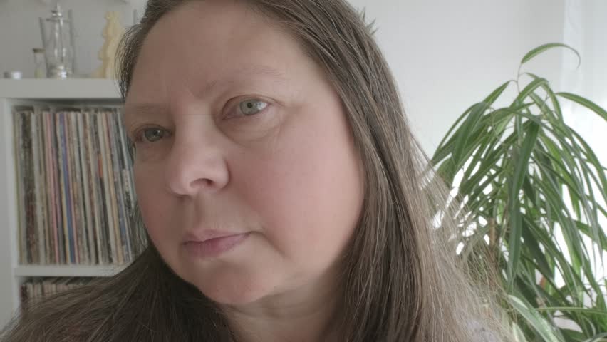 self-aware woman 50 years of age, takes moment to assess her facial features, particularly jowls, reflecting on natural process of aging and considering options for maintaining youthful appearance Royalty-Free Stock Footage #3462459515