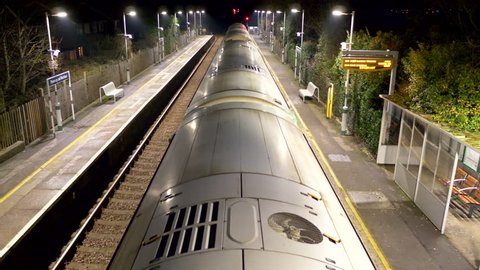 overground train leave platform at night united kingdom
