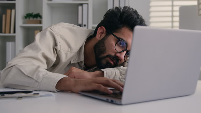 Tired sleepy exhausted Arabian Indian business man drowsy frustrated businessman worker employee sad fatigued lazy male guy sleep sleeping at office desk with laptop boring computer work overwork nap Royalty-Free Stock Footage #3462600701