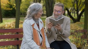 Intelligent retired couple grandparents woman man read poetry outdoor wise old husband reading book to mature wife happy Caucasian family male female relax rest romantic weekend in city autumn park - Powered by Shutterstock - Get 15% off with code: PIKWIZARD15