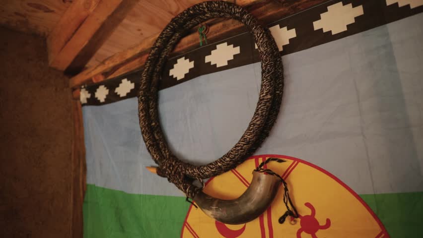 Culture and tradition. View of a Mapuche aborigine musical instrument, Ñolkin that belongs to the family of the trumpets and is made with wood and animal guts. The Mapuche flag hanging in the wall. Royalty-Free Stock Footage #3462619955