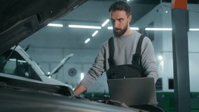 Caucasian adult man worker auto mechanic repairing car problem of engine using laptop managing computer system checking detail maintenance automotive diagnostics in automobile garage service station - Powered by Shutterstock - Get 15% off with code: PIKWIZARD15
