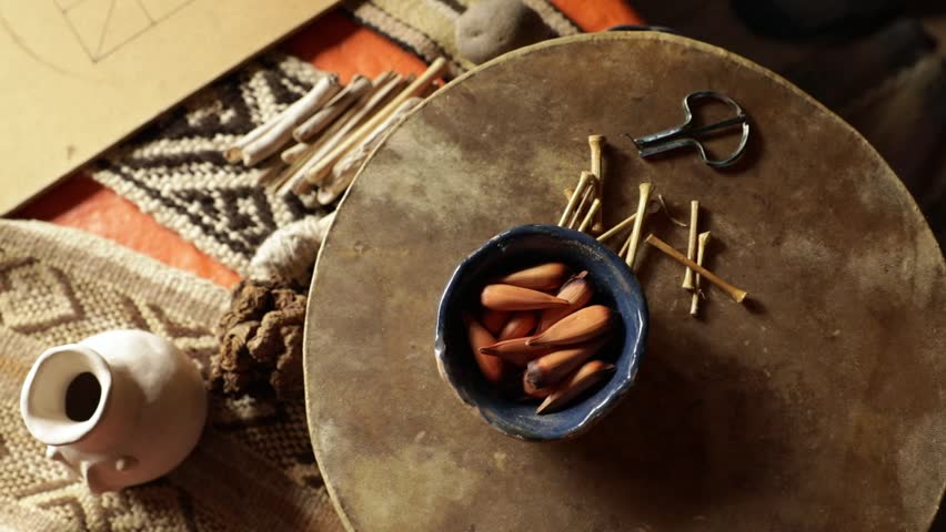 Mapuche culture and tradition. Closeup view of Mapuche aborigines musical instruments. A Trompe and mapuche sacred fruits called piñones, from Araucaria tree, laying over a a drum called Kultrun. Royalty-Free Stock Footage #3462621825