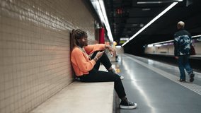 Young African American woman with vitiligo enjoying moment of connection, chatting online with friends on smartphone. Sitting in relaxed pose at subway station female interacts with her digital world - Powered by Shutterstock - Get 15% off with code: PIKWIZARD15