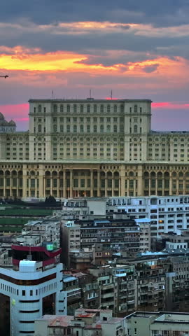 Vertical aerial drone view of Palace of the Parliament in Bucharest downtown at sunset. Romania