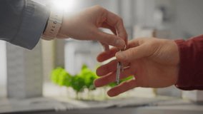 In an area with an environmentally friendly zone and modern buildings, the keys to a new house are handed over from the realtor to the buyer. Buying a home in an ecologically clean area - Powered by Shutterstock - Get 15% off with code: PIKWIZARD15