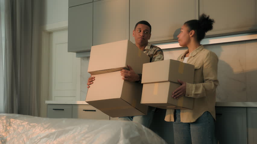 Sad upset couple African American family renters tenants leave home with cardboard boxes relocation moving day disappointed frustrated man woman move out apartment mortgage debt eviction sale house Royalty-Free Stock Footage #3462696841