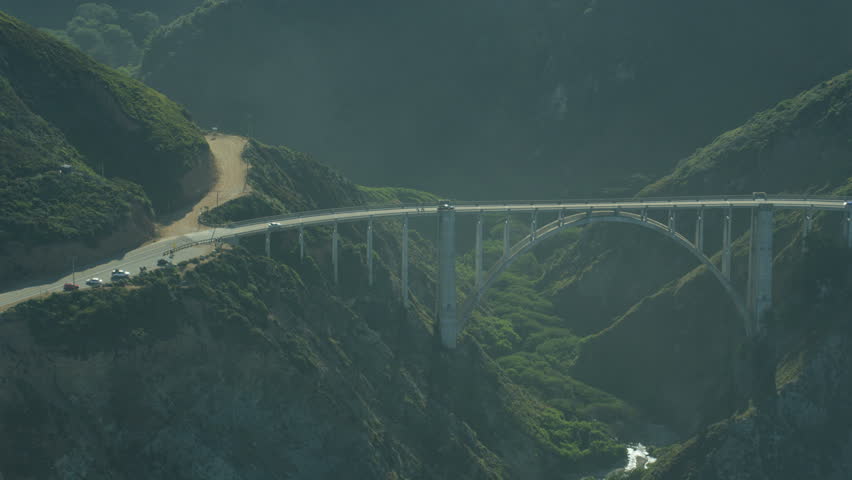 Aerial close up view vehicles travelling over Bixby Creek Bridge Cabrillo Highway Big Sur California USA RED WEAPON