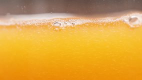Orange Juice or Soda Macro Shot, Bubbles and Liquid Level in the Glass, Slow Motion. - Powered by Shutterstock - Get 15% off with code: PIKWIZARD15