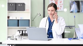 Young female doctor in white medical uniform using laptop and tablet talking video conference call at desk,Doctor sitting at desk and writing a prescription for her patient in hospital
