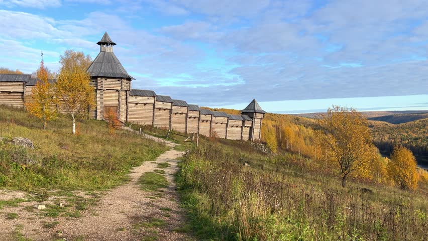 The scenery for the film The Heart of Parma in the Perm region. A large log fortress in the open air in the golden autumn. Autumn panoramic view of the fortress in the rays of the sun.