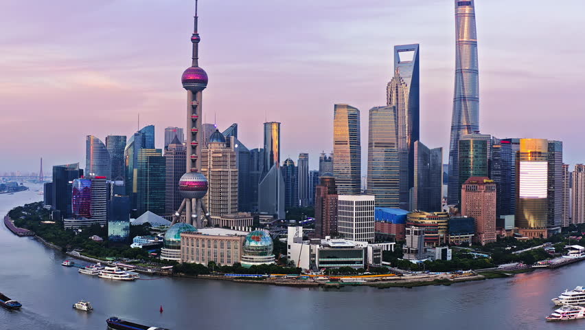 Aerial video of modern city buildings and skyscrapers scenery in Shanghai at dusk. Drone ascending to shoot.
