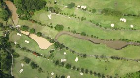 Aerial overhead drone view of tree lined on the Golf Course with water pond of water hazard and sand pond of bunker. Directly top down drone camera. Borobudur International Golf Course, Indonesia.