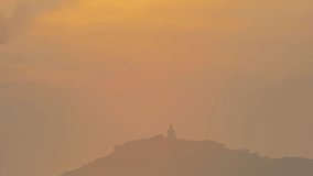Time Lapse The sun circles behind the Buddha on the mountain as the sun travels from the sky and falls behind the mountain. 
The Sky gradually changed color from yellow to orange and red over time.
