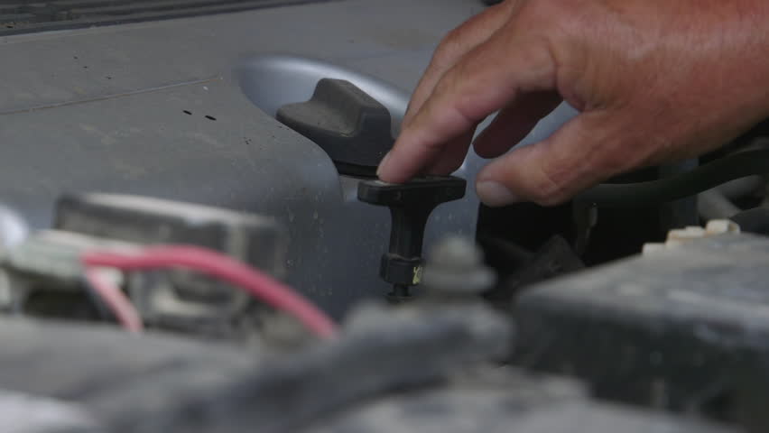Inspecting the engine oil level of a motor vehicle.