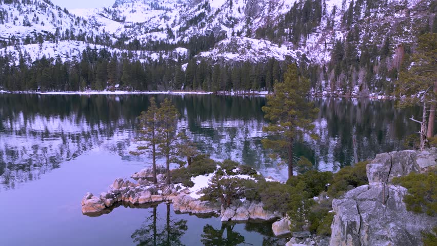 Aerial reveal of snowy mountains in Emerald Bay, Lake Tahoe, California, Desolation Wilderness